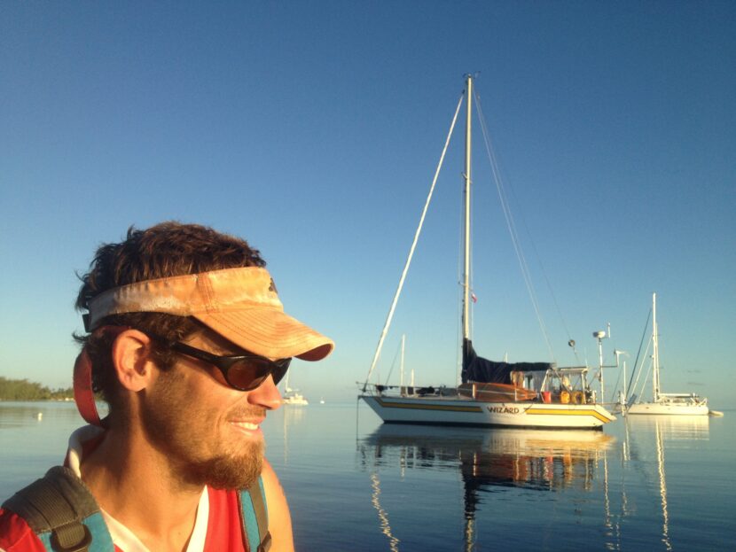 Rob Roberts smiles in front of sailboats anchored in Tahiti, French Polynesia. Photo by Brianna Randall